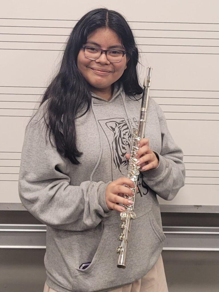 girl playing the flute that was refurbished by hungry for music